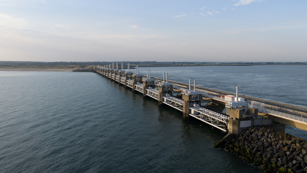 Aerial view of the Eastern Scheldt Storm Surge Barrier stretching across the water with concrete piers steel gates and rocky embankments in Vrouwenpolder Zeeland Netherlands. Aerial view of the Eastern Scheldt Storm Surge Barrier stretching across the water with concrete piers steel gates and rocky embankments in Vrouwenpolder Zeeland Netherlands.