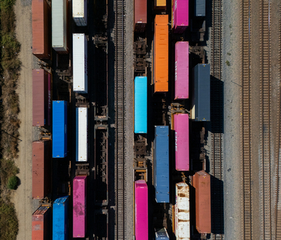 Aerial view of colorful shipping containers loaded on freight trains in a rail yard in Carson California United States.