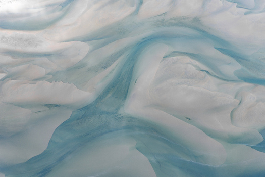 Aerial view of intricate sandbanks and turquoise tidal channels forming shifting patterns in the coastal waters of Senja Troms Norway.