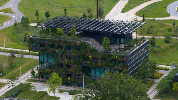 Aerial view of a modern sustainable building featuring lush green walls a rooftop garden and solar panels in Almere Flevoland Netherlands. Aerial view of a modern sustainable building featuring lush green walls a rooftop garden and solar panels in Almere Flevoland Netherlands.