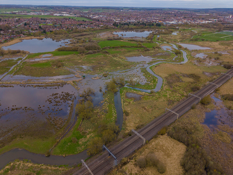 Aerial view of Doxey Marshes featuring wetlands winding river channels and a railway line crossing the landscape in Stafford England United Kingdom. Aerial view of Doxey Marshes featuring wetlands winding river channels and a railway line crossing the landscape in Stafford England United Kingdom.