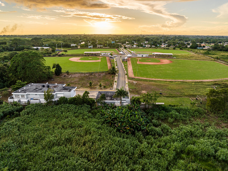 Aerial view of Quality Baseball Academy with baseball fields lush greenery and modern facilities under a sunset sky in San Antonio de Guerra Santo Domingo Provinc Dominican Republic. Aerial view of Quality Baseball Academy with baseball fields lush greenery and modern facilities under a sunset sky in San Antonio de Guerra Santo Domingo Provinc Dominican Republic.