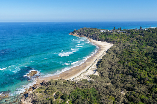 Aerial view of North Stradbroke Island coastline with turquoise ocean waves sandy beach and dense green vegetation in Redland City Queensland Australia. Aerial view of North Stradbroke Island coastline with turquoise ocean waves sandy beach and dense green vegetation in Redland City Queensland Australia.