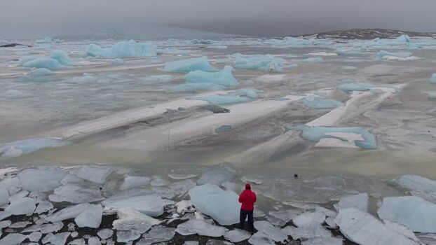 Aerial view of a person in a red jacket at Fjallsarlon Iceland. Aerial view of a person in a red jacket at Fjallsarlon Iceland.