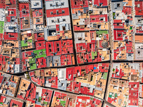 Aerial view of a dense urban landscape featuring a maze of red tiled rooftops narrow streets and small green terraces in Andalusia Spain. Aerial view of a dense urban landscape featuring a maze of red tiled rooftops narrow streets and small green terraces in Andalusia Spain.