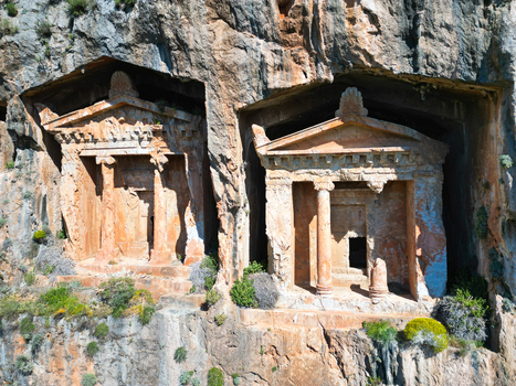 Aerial view of the ancient Lycian rock tombs of Kaunos carved into the steep cliff face with stone columns and intricate facades in Dalyan Mugla Turkiye. Aerial view of the ancient Lycian rock tombs of Kaunos carved into the steep cliff face with stone columns and intricate facades in Dalyan Mugla Turkiye.
