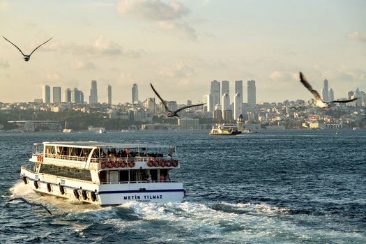 View of a passenger ferry crossing the Bosphorus with the Istanbul skyline in the background during golden hour in Istanbul Turkey. View of a passenger ferry crossing the Bosphorus with the Istanbul skyline in the background during golden hour in Istanbul Turkey.