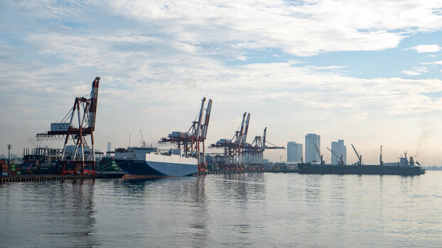 View of the Cebu Port Authority with large cargo ships docked alongside towering cranes under a soft morning sky in Cebu City Central Visayas Philippines. View of the Cebu Port Authority with large cargo ships docked alongside towering cranes under a soft morning sky in Cebu City Central Visayas Philippines.