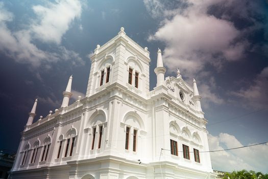 View of the historic white Meeran Jumma Mosque with its colonial architecture and minarets under a dramatic cloudy sky in Galle Southern Province Sri Lanka.