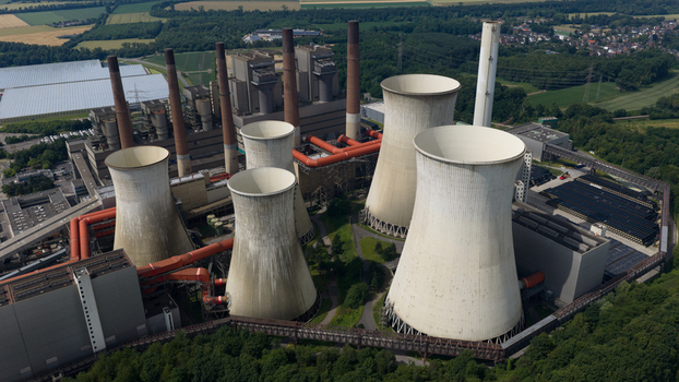Aerial view of Kraftwerk Niederaussem power plant featuring massive cooling towers and industrial infrastructure surrounded by lush greenery in Bergheim Nordrhein Westfalen Germany. Aerial view of Kraftwerk Niederaussem power plant featuring massive cooling towers and industrial infrastructure surrounded by lush greenery in Bergheim Nordrhein Westfalen Germany.