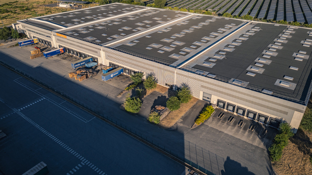 Le Pouzin France 04 July 2026 Aerial view of the SKIPPER Logistique warehouse and distribution center featuring loading docks parked trucks and nearby solar panel arrays. Le Pouzin France 04 July 2026 Aerial view of the SKIPPER Logistique warehouse and distribution center featuring loading docks parked trucks and nearby solar panel arrays.