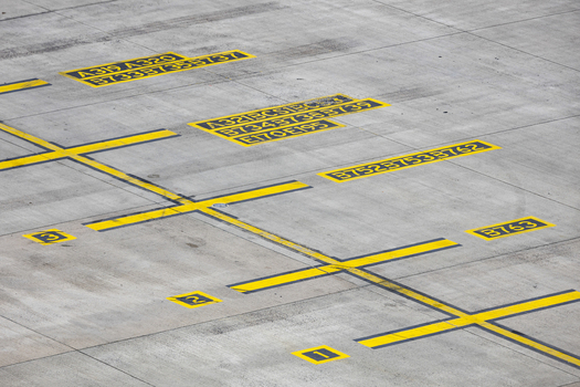 View of yellow aircraft parking markings and aircraft type codes on the concrete tarmac at Berlin Brandenburg Airport BER Berlin Brandenburg Germany.
