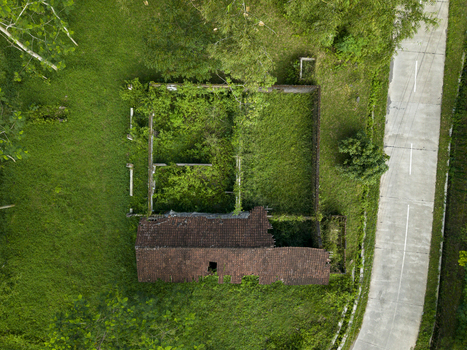 Aerial view of Houses Damaged by Mount Merapi Eruption showing a ruined structure with a broken roof and overgrown vegetation in Cangkringan Special Region of Yogyakarta Indonesia. Aerial view of Houses Damaged by Mount Merapi Eruption showing a ruined structure with a broken roof and overgrown vegetation in Cangkringan Special Region of Yogyakarta Indonesia.