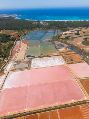Aerial view of Salines des Trenc salt evaporation ponds with pink and blue water near the Mediterranean coast in Campos Islas Baleares Spain. Aerial view of Salines des Trenc salt evaporation ponds with pink and blue water near the Mediterranean coast in Campos Islas Baleares Spain.