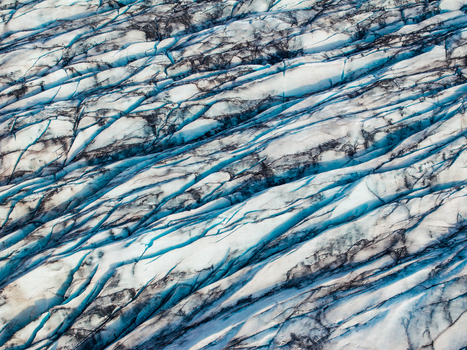 Aerial view of the intricate patterns of deep blue crevasses and white snow on the surface of a glacier in Iceland. Aerial view of the intricate patterns of deep blue crevasses and white snow on the surface of a glacier in Iceland.