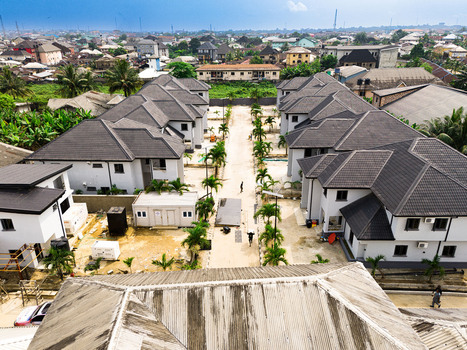 Aerial view of modern residential houses with grey roofs and palm trees along a central driveway Port Harcourt Rivers Nigeria. Aerial view of modern residential houses with grey roofs and palm trees along a central driveway Port Harcourt Rivers Nigeria.