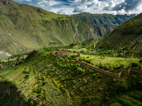 Aerial view of the ancient Pumamarca Ruins in the Sacred Valley featuring stone walls and agricultural terraces set against a dramatic mountainous landscape in Pallata Qosqo Peru.