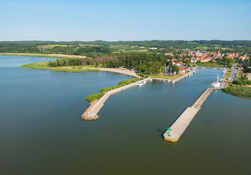 Aerial view of Port Tolkmicko with concrete breakwaters a marina and the town waterfront on the Vistula Lagoon in Warmia Masuria northern Poland. Aerial view of Port Tolkmicko with concrete breakwaters a marina and the town waterfront on the Vistula Lagoon in Warmia Masuria northern Poland.