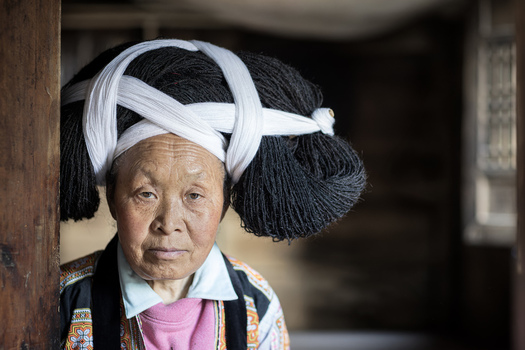 Gaoxing China 29 April 2026 View of a Long Horn Miao woman wearing a traditional large black hairpiece wrapped with white cloth and embroidered ethnic clothing in a wooden house. Gaoxing China 29 April 2026 View of a Long Horn Miao woman wearing a traditional large black hairpiece wrapped with white cloth and embroidered ethnic clothing in a wooden house.