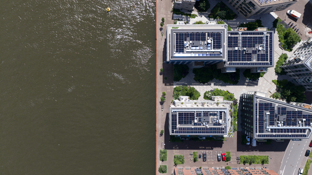 Aerial view of modern residential buildings with solar panels on rooftops along the Cruquiusweg canal in Amsterdam Noord Holland Netherlands.