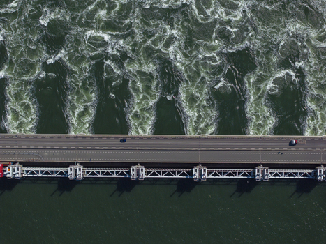 Aerial view of the Eastern Scheldt Storm Surge Barrier with a road crossing the structure and turbulent water flowing through the sluice gates in Vrouwenpolder Zeeland Netherlands. Aerial view of the Eastern Scheldt Storm Surge Barrier with a road crossing the structure and turbulent water flowing through the sluice gates in Vrouwenpolder Zeeland Netherlands.