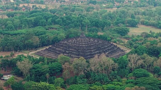 Aerial view of Borobudur Temple surrounded by lush forest Indonesia.