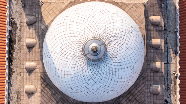 Aerial view of the intricate white dome of the Great Mosque of Central Java featuring a geometric pattern and surrounding tiled roof in Kecamatan Gayamsari Jawa Tengah Indonesia. Aerial view of the intricate white dome of the Great Mosque of Central Java featuring a geometric pattern and surrounding tiled roof in Kecamatan Gayamsari Jawa Tengah Indonesia.