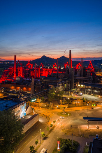 Volklingen Germany 09 May 2026 Aerial view of Volklingen Ironworks illuminated with red lights at dusk featuring industrial chimneys and historic blast furnaces against a sunset sky. Volklingen Germany 09 May 2026 Aerial view of Volklingen Ironworks illuminated with red lights at dusk featuring industrial chimneys and historic blast furnaces against a sunset sky.