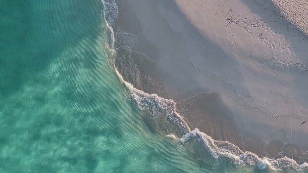 Aerial view of turquoise waves washing onto a sandy beach Maldives. Aerial view of turquoise waves washing onto a sandy beach Maldives.