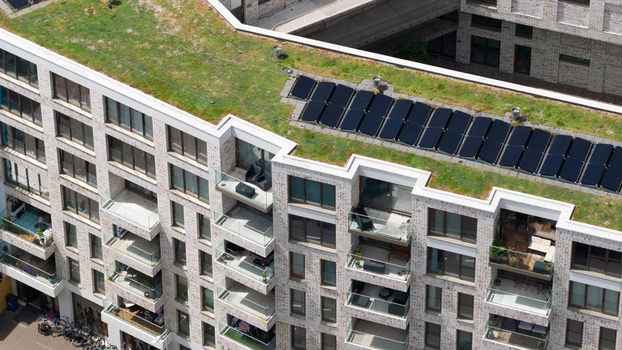 Aerial view of a modern apartment building on Cruquiusweg featuring a green roof with solar panels and private balconies in Amsterdam Noord Holland Netherlands.