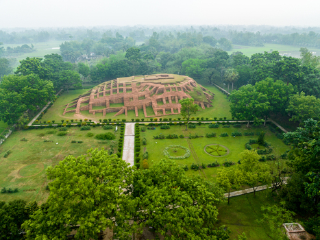 Aerial view of the ancient Gokul Medh archaeological site with its terraced brick ruins surrounded by lush green gardens and trees in Bogura Rajshahi Division Bangladesh.