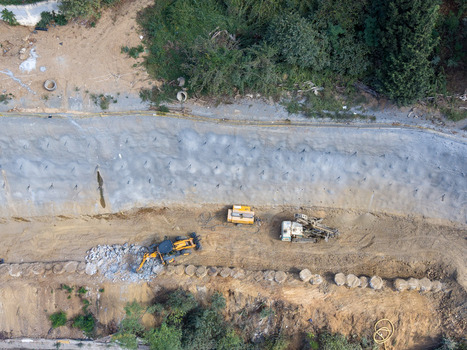 Aerial view of construction machinery working on a soil stabilization project with a concrete retaining wall in Istanbul Istanbul Turkiye. Aerial view of construction machinery working on a soil stabilization project with a concrete retaining wall in Istanbul Istanbul Turkiye.