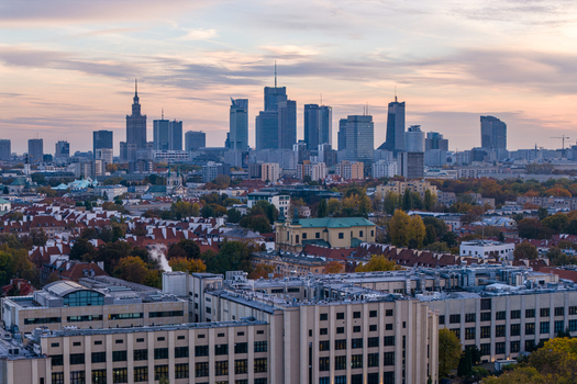 Warsaw Poland 21 October 2024 Aerial view of the Warsaw skyline featuring modern skyscrapers historic rooftops and autumn foliage under a soft sunset sky. Warsaw Poland 21 October 2024 Aerial view of the Warsaw skyline featuring modern skyscrapers historic rooftops and autumn foliage under a soft sunset sky.
