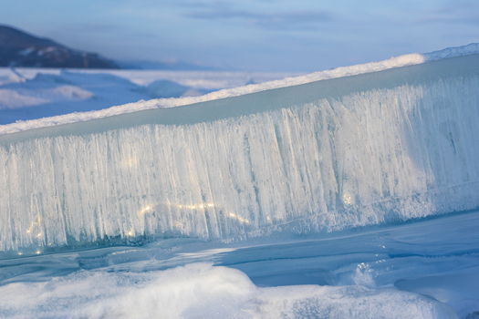 View of a large translucent ice block with vertical textures on the frozen surface of Lake Baikal in Severobaykalsk Buryatia Russia. View of a large translucent ice block with vertical textures on the frozen surface of Lake Baikal in Severobaykalsk Buryatia Russia.