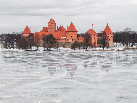 Aerial view of Trakai Island Castle with its red brick towers and walls surrounded by a frozen lake under a cloudy winter sky in Trakai Vilnius County Lithuania. Aerial view of Trakai Island Castle with its red brick towers and walls surrounded by a frozen lake under a cloudy winter sky in Trakai Vilnius County Lithuania.