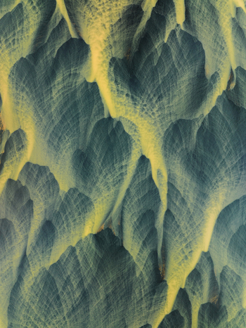 Aerial view of a tapestry of textures where icy blues meet streaks of golden earth in Iceland s rugged highlands creating an otherworldly landscape. Iceland Iceland. Aerial view of a tapestry of textures where icy blues meet streaks of golden earth in Iceland s rugged highlands creating an otherworldly landscape. Iceland Iceland.