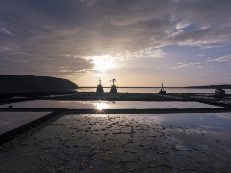 Aerial view of Salinas de Janubio salt pans at sunset with reflective water pools historic windmills and dramatic sky Lanzarote Canarias Spain. Aerial view of Salinas de Janubio salt pans at sunset with reflective water pools historic windmills and dramatic sky Lanzarote Canarias Spain.