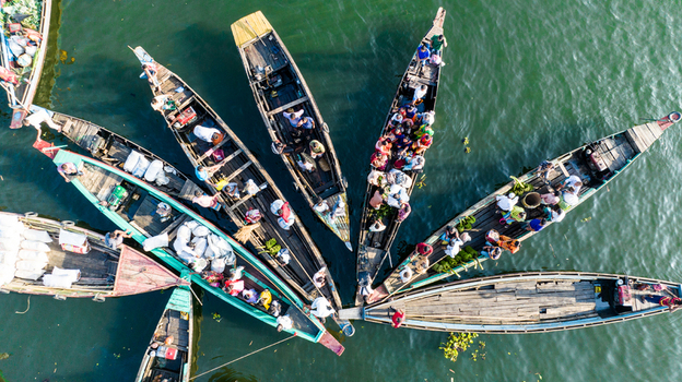 Rangamati Bangladesh 19 October 2022 Aerial view of traditional wooden boats filled with people and goods on Kaptai Lake showcasing local transport and trade in Chittagong Division.
