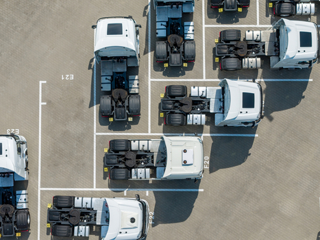 Aerial view of white semi truck cabs parked in an organized lot with marked spaces in Warsaw Masovian Voivodeship Poland. Aerial view of white semi truck cabs parked in an organized lot with marked spaces in Warsaw Masovian Voivodeship Poland.