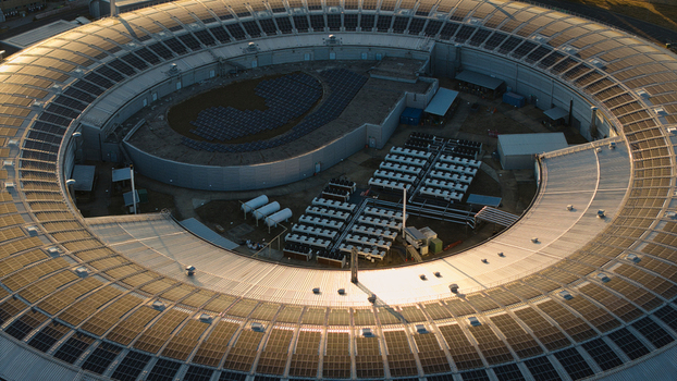 Aerial view of Diamond Light Source a circular synchrotron facility surrounded by greenery under golden hour light in Didcot United Kingdom.