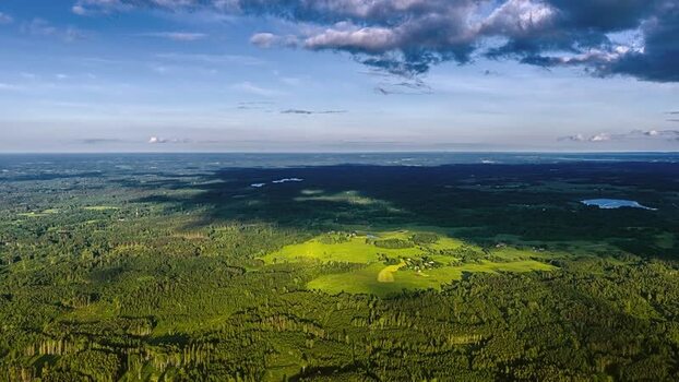 Aerial view of lush green forests and open fields in Latvia. Aerial view of lush green forests and open fields in Latvia.