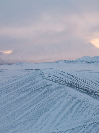 Aerial view of Hverfjall crater covered in snow with volcanic ridges under a soft cloudy sky in Thingeyjarsveit Iceland. Aerial view of Hverfjall crater covered in snow with volcanic ridges under a soft cloudy sky in Thingeyjarsveit Iceland.