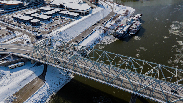 Aerial view of the steel truss bridge crossing the Ohio River with ice floes in the water and snow covered banks in Cincinnati Ohio United States. Aerial view of the steel truss bridge crossing the Ohio River with ice floes in the water and snow covered banks in Cincinnati Ohio United States.