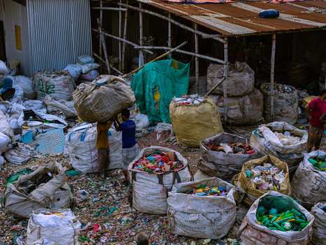 Keraniganj Bangladesh 20 May 2026 Aerial view of workers sorting and carrying large sacks of plastic waste at a recycling yard near the Buriganga River. Keraniganj Bangladesh 20 May 2026 Aerial view of workers sorting and carrying large sacks of plastic waste at a recycling yard near the Buriganga River.