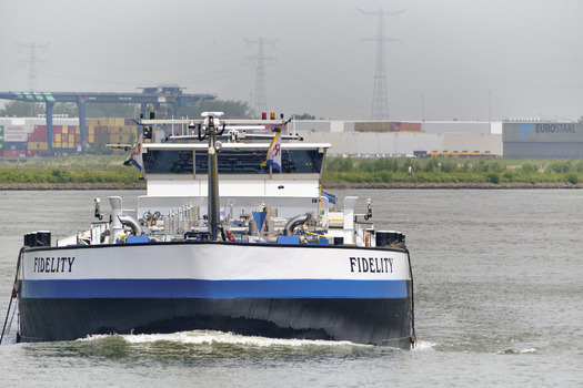 Dordrecht South Holland Netherlands 31 May 2026 View of the inland tanker ship Fidelity navigating the Oude Maas river past industrial harbor facilities and container terminals.