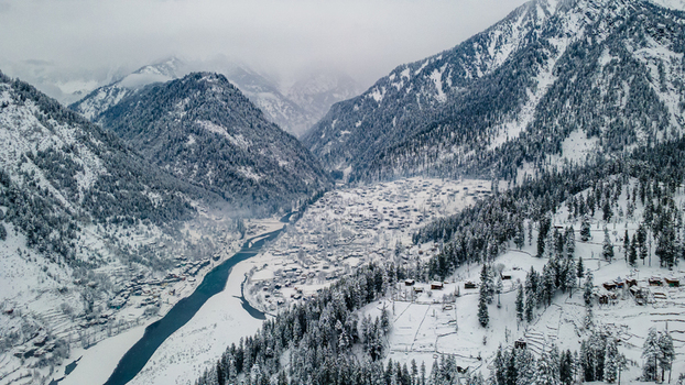 Aerial view of a snow laden Sharda nestled in a valley the river snaking through the landscape framed by majestic mountains Sharda Azad Kashmir Pakistan. Aerial view of a snow laden Sharda nestled in a valley the river snaking through the landscape framed by majestic mountains Sharda Azad Kashmir Pakistan.