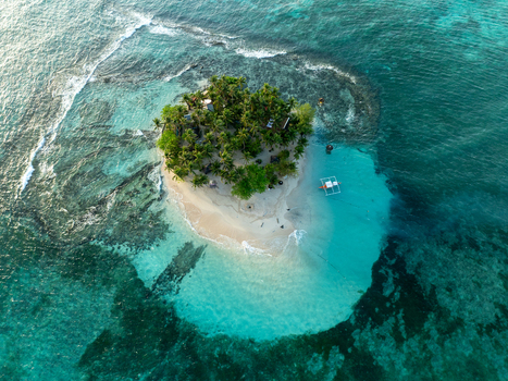 Aerial view of Naked Island with lush palm trees and white sand beaches surrounded by turquoise coral reefs in Siargao Philippines. Aerial view of Naked Island with lush palm trees and white sand beaches surrounded by turquoise coral reefs in Siargao Philippines.