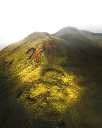 Aerial view of a green mountain crest during a foggy day near Lajes do Pico Azores Portugal.