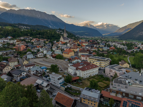 Aerial view of the alpine town of Imst featuring historic church architecture residential buildings and surrounding mountain valley landscapes in Imst Tyrol Austria.