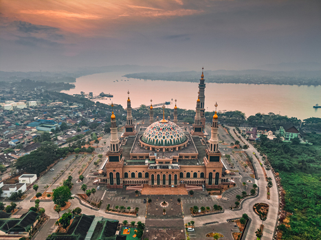 Aerial view of the Baitul Muttaqien Mosque the East Kalimantan Islamic Center with its grand dome and minarets overlooking the Mahakam River in Samarinda East Kalimantan Indonesia.
